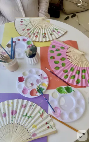 Leques sendo pintados em experiência personalizada